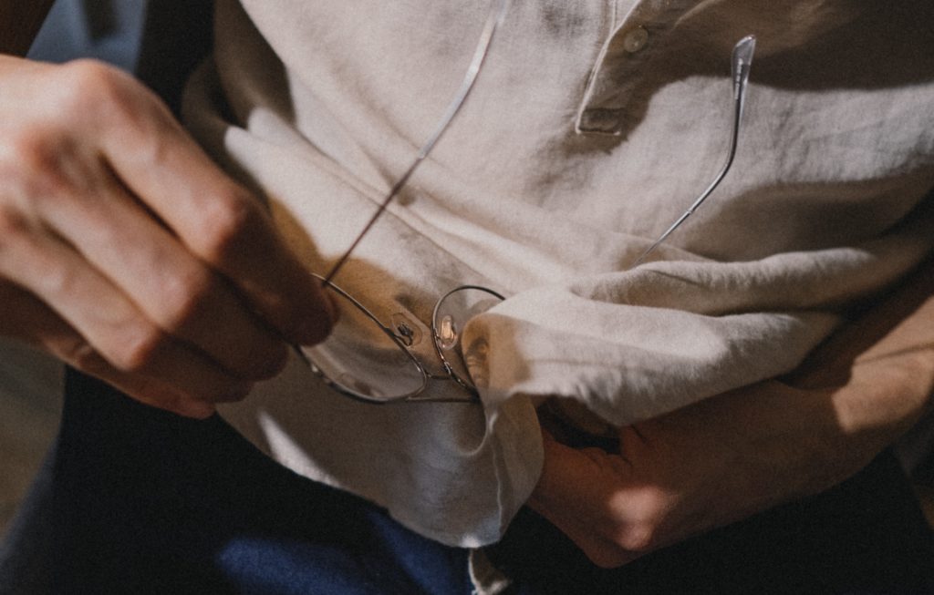 Brille wird mit Hemd geputzt